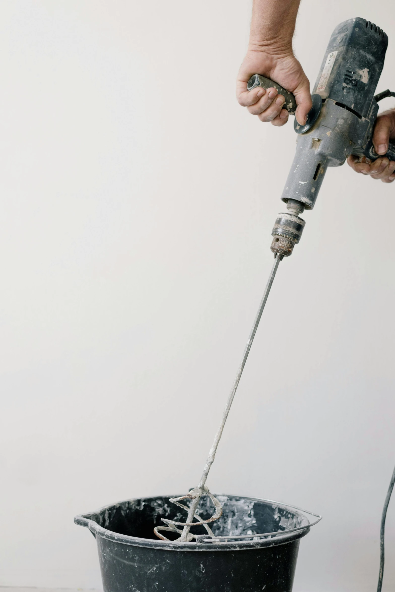 a person using a power drill on a bucket, by Ben Zoeller, unsplash, arbeitsrat für kunst, on a pale background, on a white table, cement, hanging