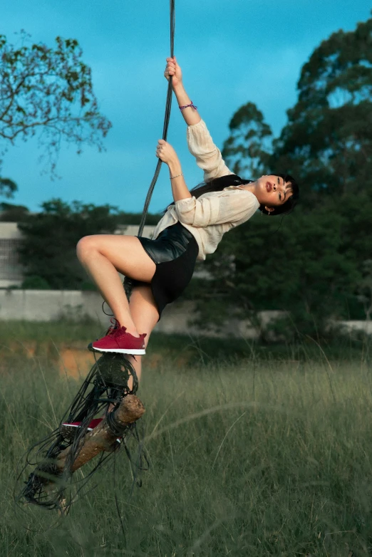 a woman swinging on a rope in a field, pexels contest winner, ariana grande on a tricycle, in australia, kiko mizuhara, climber