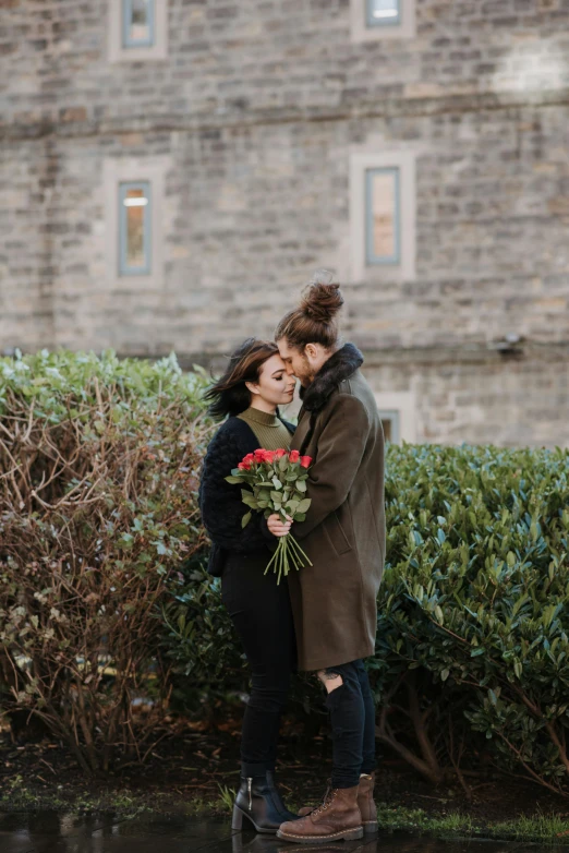 a man and woman standing next to each other in front of a building, pexels contest winner, romanticism, lesbian kiss, roses, edinburgh, february)