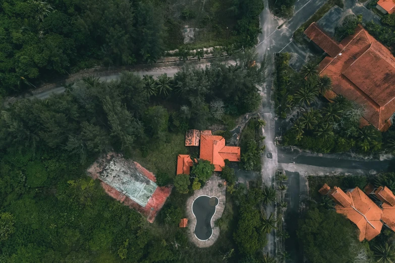 an aerial view of a house surrounded by trees, a screenshot, pexels contest winner, abandoned streets, resort, drone photo, orange roof