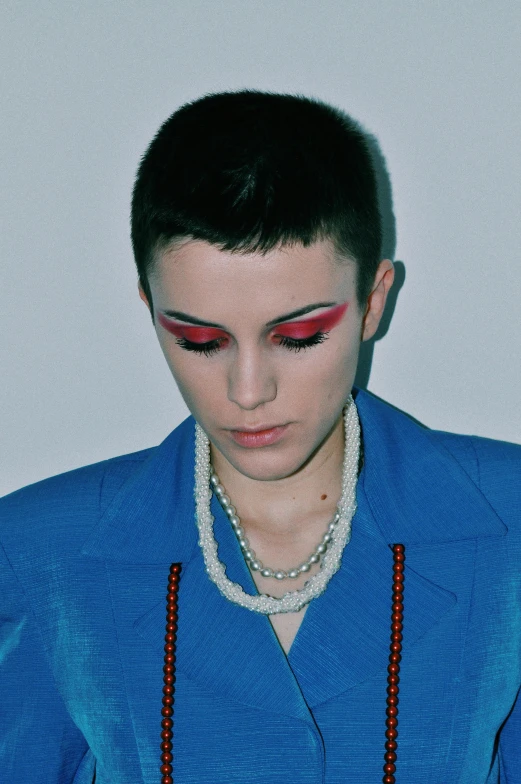 a close up of a person holding a cell phone, an album cover, inspired by Jean Malouel, white eyebrows, red and blue garments, nonbinary model, wearing collar
