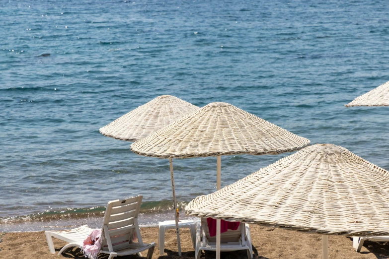 a number of chairs and umbrellas on a beach, pexels contest winner, hydra, wearing a white bathing cap, view of sea, demna gvasalia