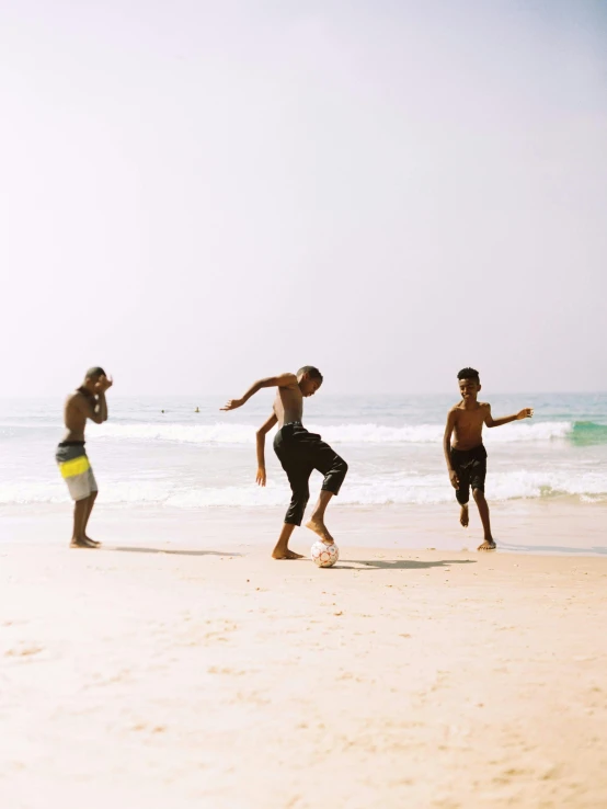 a group of young men playing a game of soccer on a beach, by Briana Mora, pexels contest winner, childish gambino, malayalis attacking, instagram story, hd footage