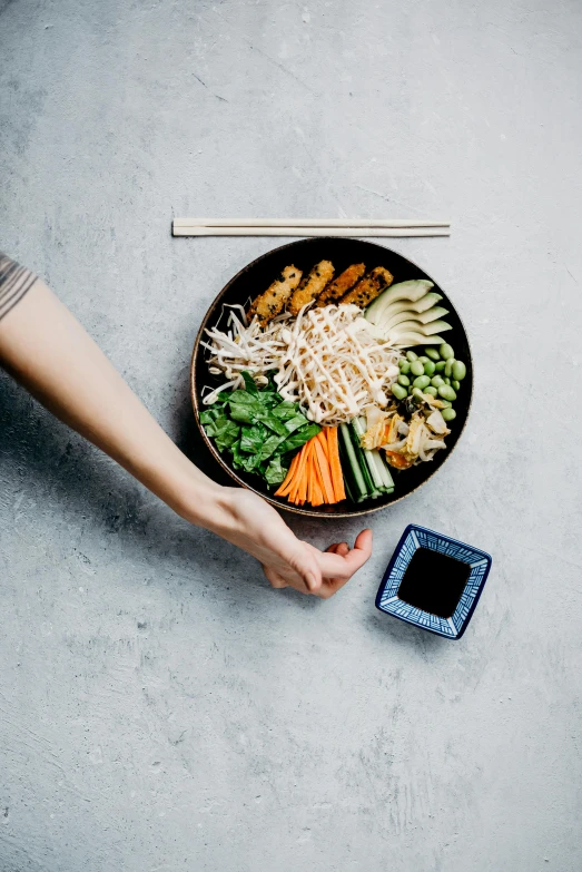 a person holding a bowl of food with chopsticks, profile image, veggies, full product shot, 2019 trending photo