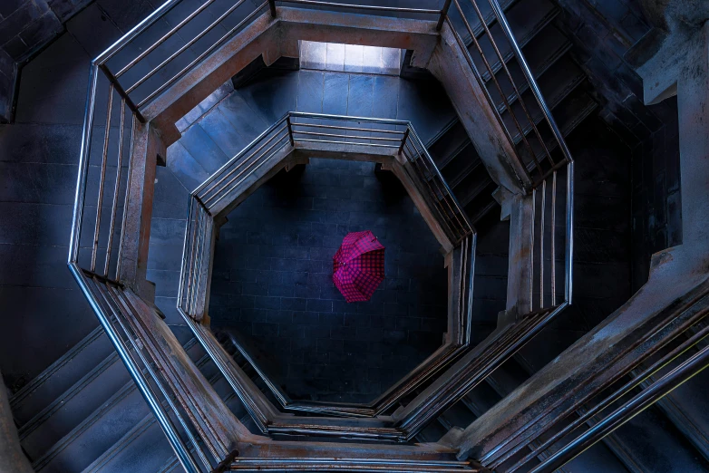 a red umbrella sitting inside of a building, inspired by Storm Thorgerson, unsplash contest winner, process art, hogwarts stairwell, magenta and blue, hexagonal ring, taken with canon 5d mk4