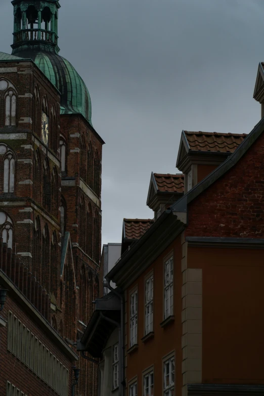 a clock that is on the side of a building, by Carl-Henning Pedersen, romanesque, dark gloomy church, red building, hiding in the rooftops, street photo