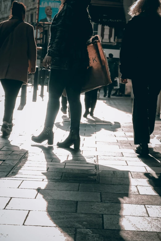 a group of people walking down a sidewalk, pexels contest winner, contrasting shadows, people shopping, low quality photo, ilustration