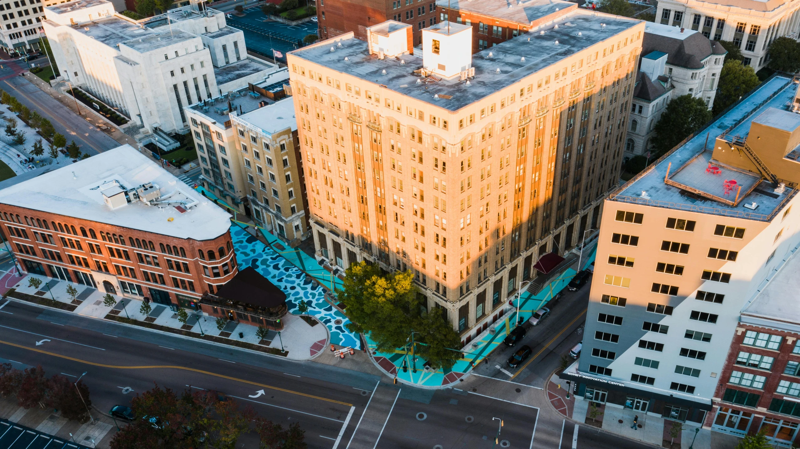 an aerial view of a city with tall buildings, a portrait, by Meredith Dillman, unsplash contest winner, process art, sunken square, bentonville arkansas, outdoor art installation, orange and cyan lighting