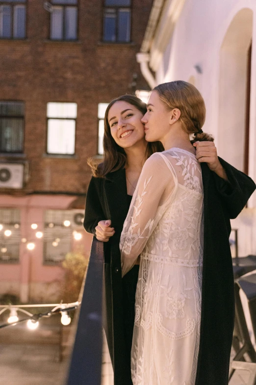 a couple of women standing next to each other, trending on pexels, happening, rooftop romantic, wearing a wedding dress, alexandria ocasio cortez, orthodox