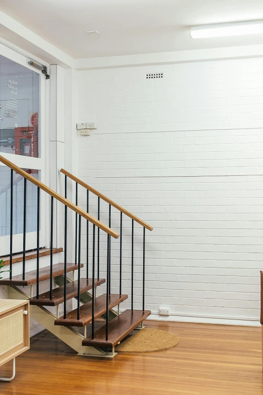 a living room filled with furniture and a wooden staircase, an album cover, by Miyamoto, unsplash, light and space, white background wall, 2 5 6 x 2 5 6 pixels, metal cladding wall, whiteboard