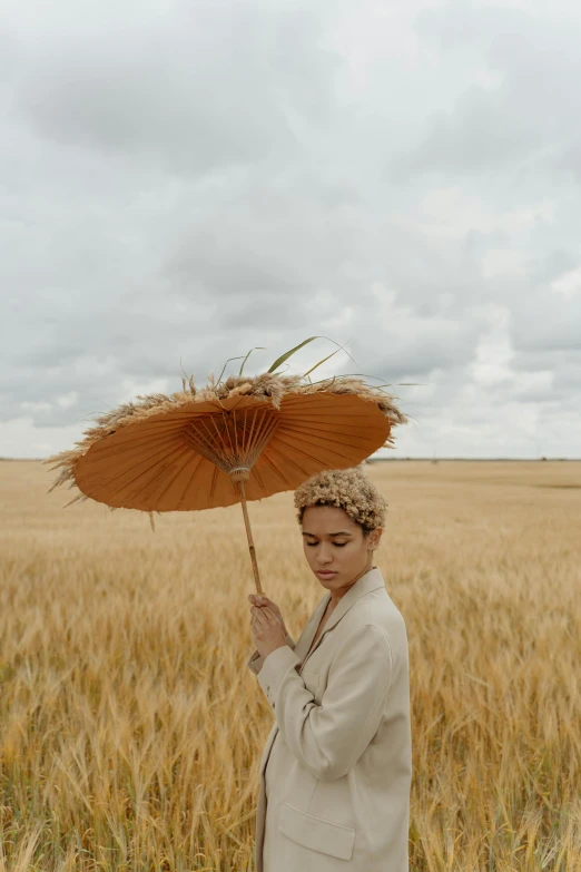 a woman standing in a wheat field holding an umbrella, unsplash, portrait of willow smith, lut, grain”, photographed for reuters