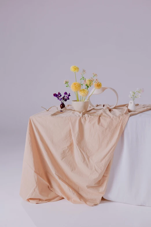 a table that has a bunch of flowers on it, a still life, unsplash, plain background, flowing fabric, tall, pastel'