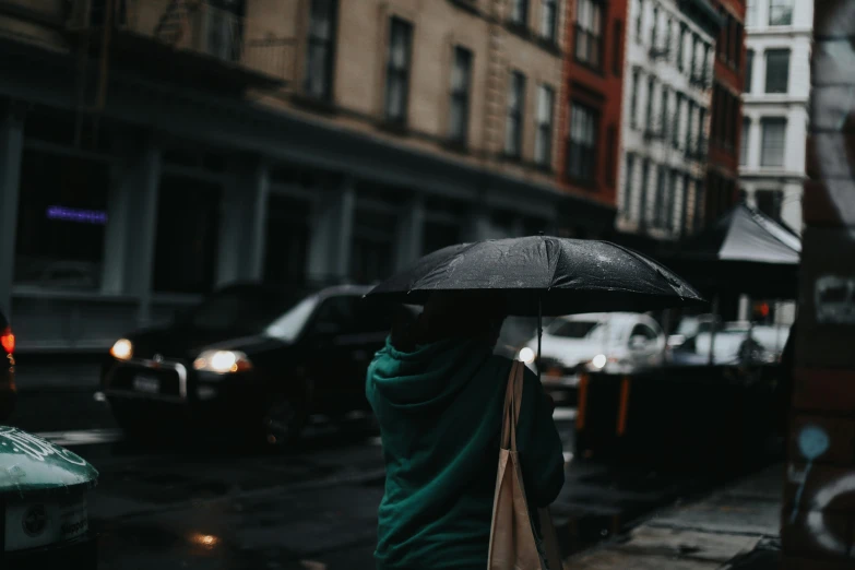 a person walking in the rain with an umbrella, pexels contest winner, underexposed grey, standing in a city street, background image, instagram post