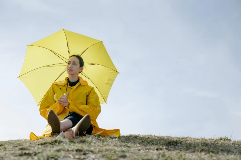 a woman sitting on the ground holding a yellow umbrella, unsplash, hyperrealism, oona chaplin, animation still, spring day, looking at the sky