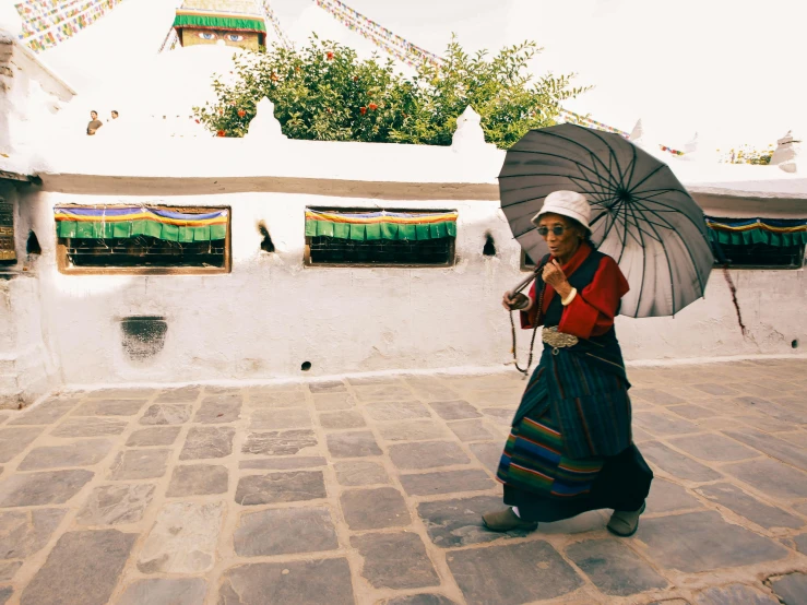 a woman walking down a street holding an umbrella, a photo, unsplash contest winner, cloisonnism, tibet, in a monestry natural lighting, jenny seville, white