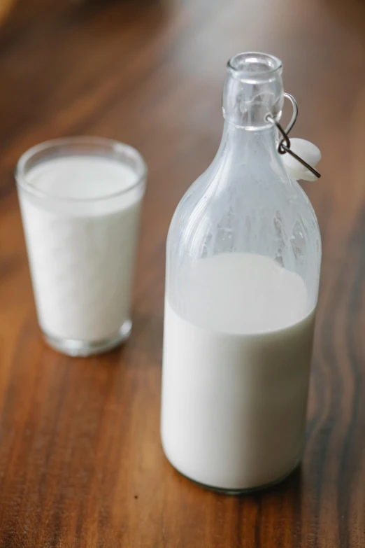 a bottle of milk next to a glass of milk, by Ben Zoeller, contain