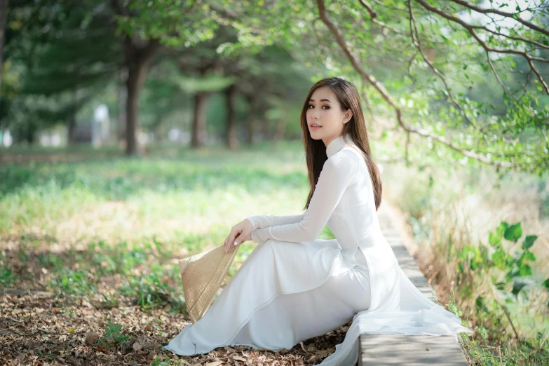 a woman sitting on the ground in a white dress, inspired by Kim Du-ryang, pexels contest winner, ao dai, 15081959 21121991 01012000 4k, portrait of a beautiful, a handsome