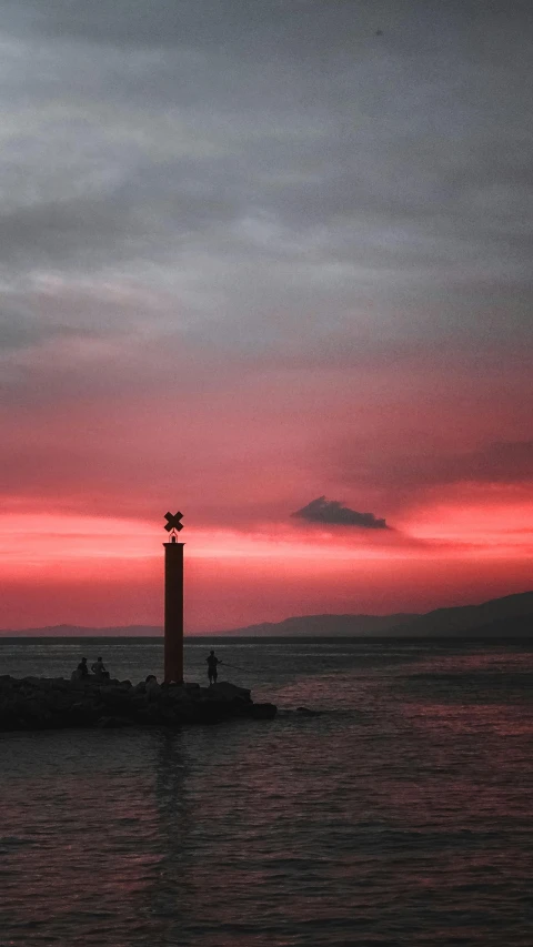 a lighthouse in the middle of a body of water, by Alexis Grimou, pexels contest winner, romanticism, redpink sunset, pillar, gulf of naples, silhouette