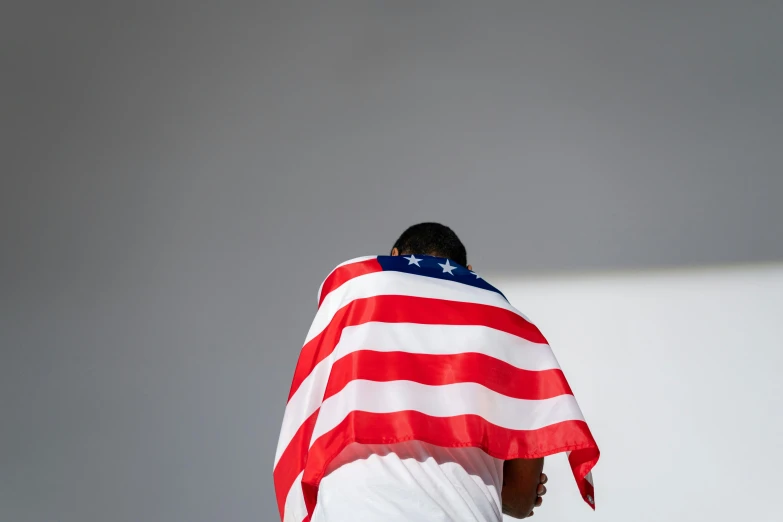 a man is wrapped in an american flag, unsplash, ignant, hunched over, american progress, photographed for reuters