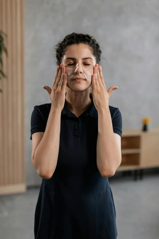 a woman holding her hands up to her face, inspired by Marina Abramović, renaissance, yoga meditation pose, square facial structure, partially cupping her hands, photograph taken in 2 0 2 0