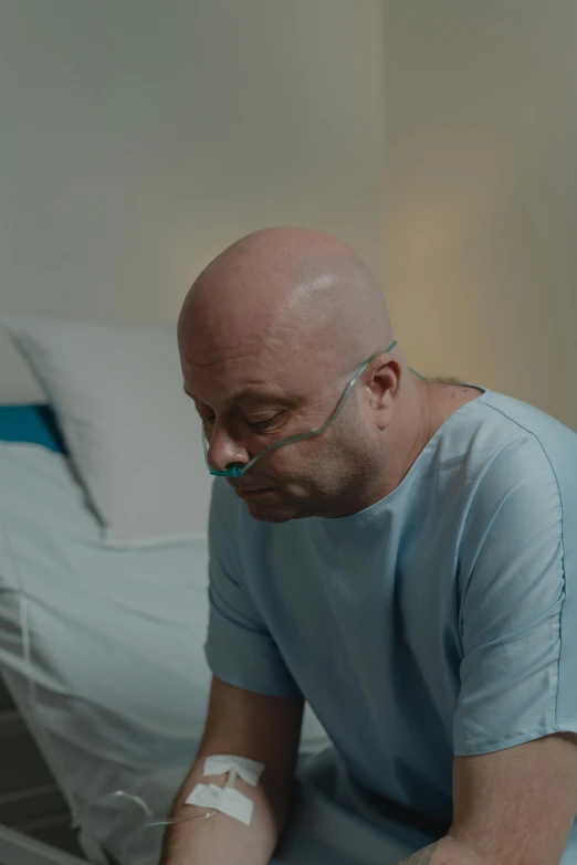 a man sitting on a bed in a hospital room, hyperrealism, partially bald, calmly conversing 8k, head down, film still promotional image