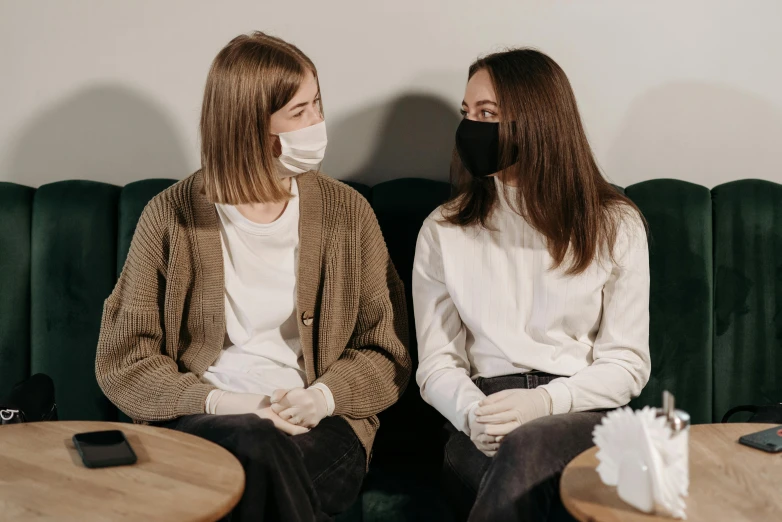 a couple of women sitting on top of a green couch, trending on pexels, antipodeans, white man with black fabric mask, sitting in a waiting room, avatar image, sitting in a cafe