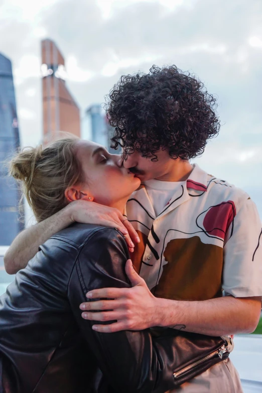 a man and a woman kissing in front of a city skyline, inspired by Nan Goldin, trending on pexels, happening, robert sheehan, pale skin curly blond hair, square, russia