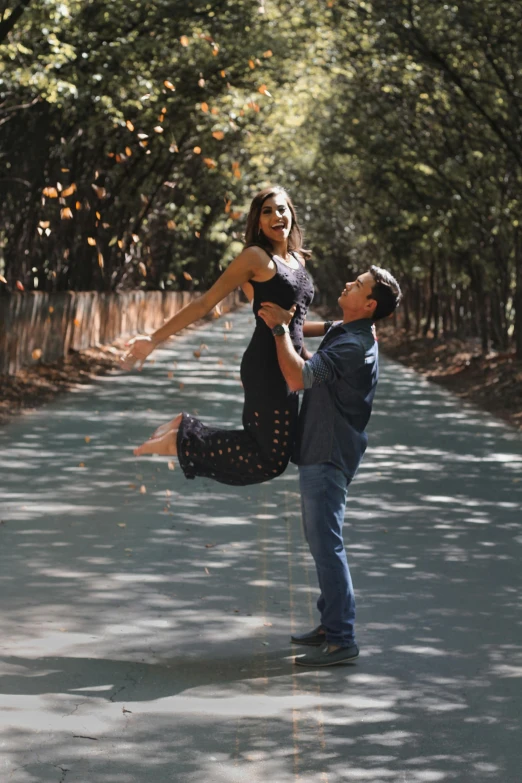 a man standing next to a woman on a road, arabesque, playful pose, lush surroundings, in savannah, midair