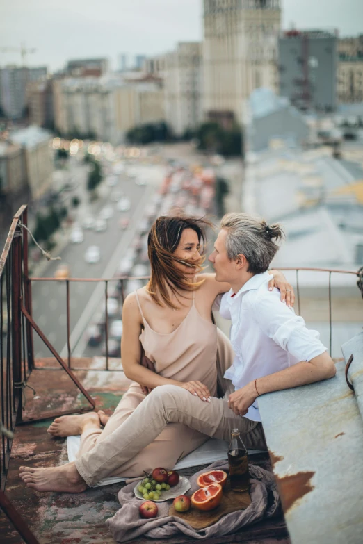 a man and a woman sitting on top of a building, by Julia Pishtar, pexels contest winner, romanticism, lesbian embrace, in russia, looking down on the camera, 15081959 21121991 01012000 4k