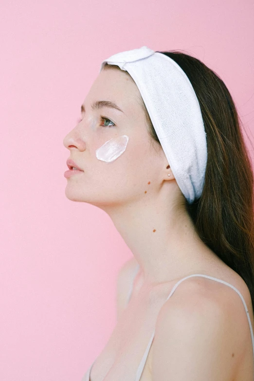 a woman with a white towel on her head, trending on pexels, glowing pink face, cream, profile pose, ad image