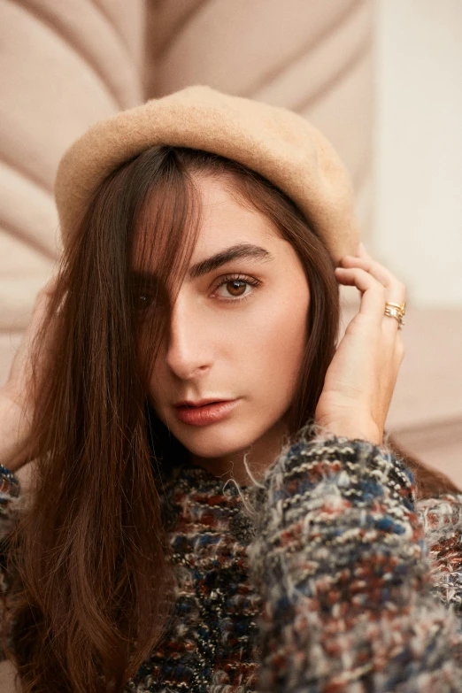 a woman sitting on a couch wearing a hat, a portrait, inspired by Marie-Gabrielle Capet, trending on pexels, brown colored long hair, wearing a beret, close-up shoot, promotional image