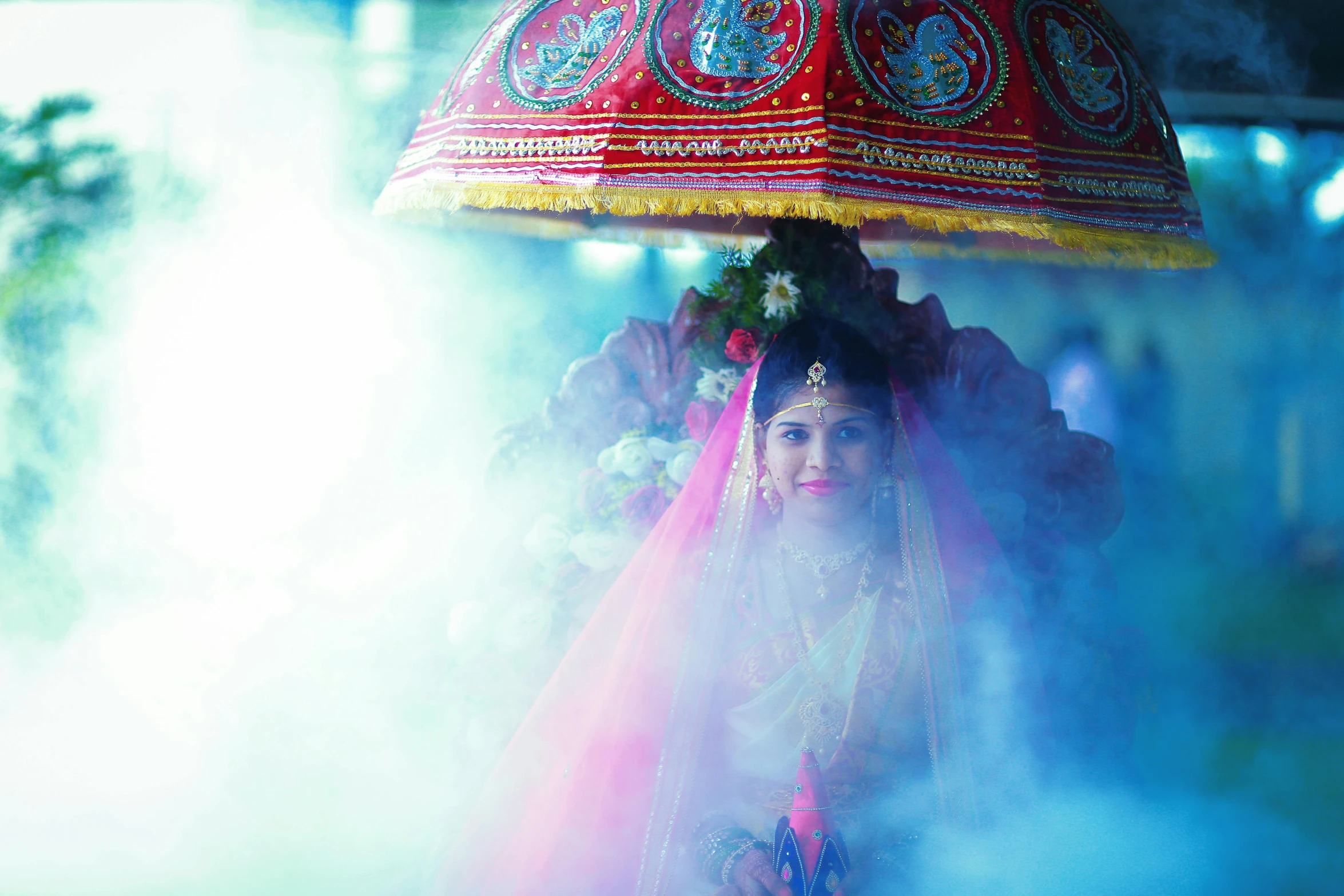 a close up of a person holding an umbrella, by Sudip Roy, pexels contest winner, holy ceremony, beautiful look, pink and blue and green mist, thumbnail