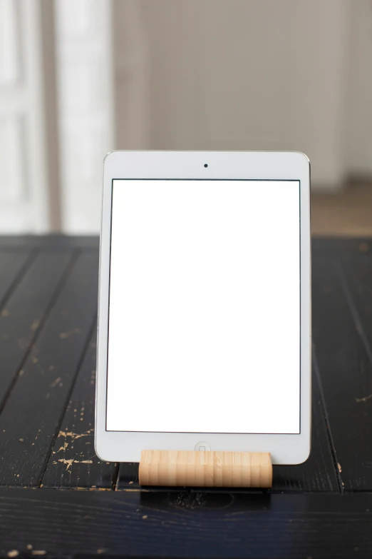a tablet computer sitting on top of a wooden table, by Carey Morris, modernism, 2 5 6 x 2 5 6 pixels, sleek white, medium angle, product shot