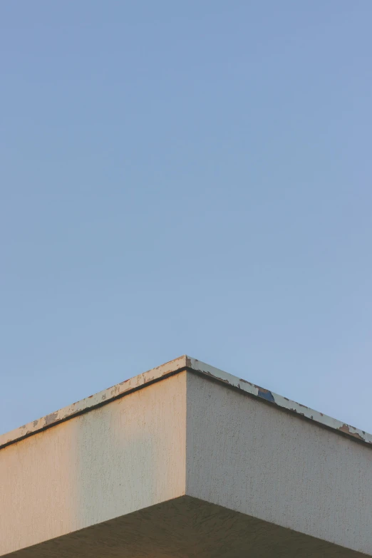 a man riding a skateboard up the side of a building, a minimalist painting, inspired by Zhang Kechun, postminimalism, cloudless-crear-sky, geometric abstraction, shed roof, (golden hour)