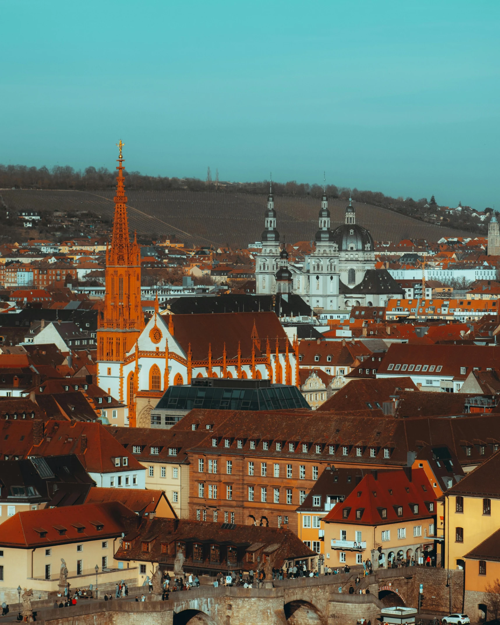 a view of a city from the top of a hill, by Jakob Gauermann, pexels contest winner, baroque, orange roof, cover image, cathedral in the background, red peaks in the background