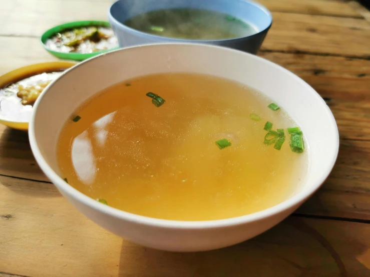 a bowl of soup sitting on top of a wooden table, banchou, sparkling, wash, honey
