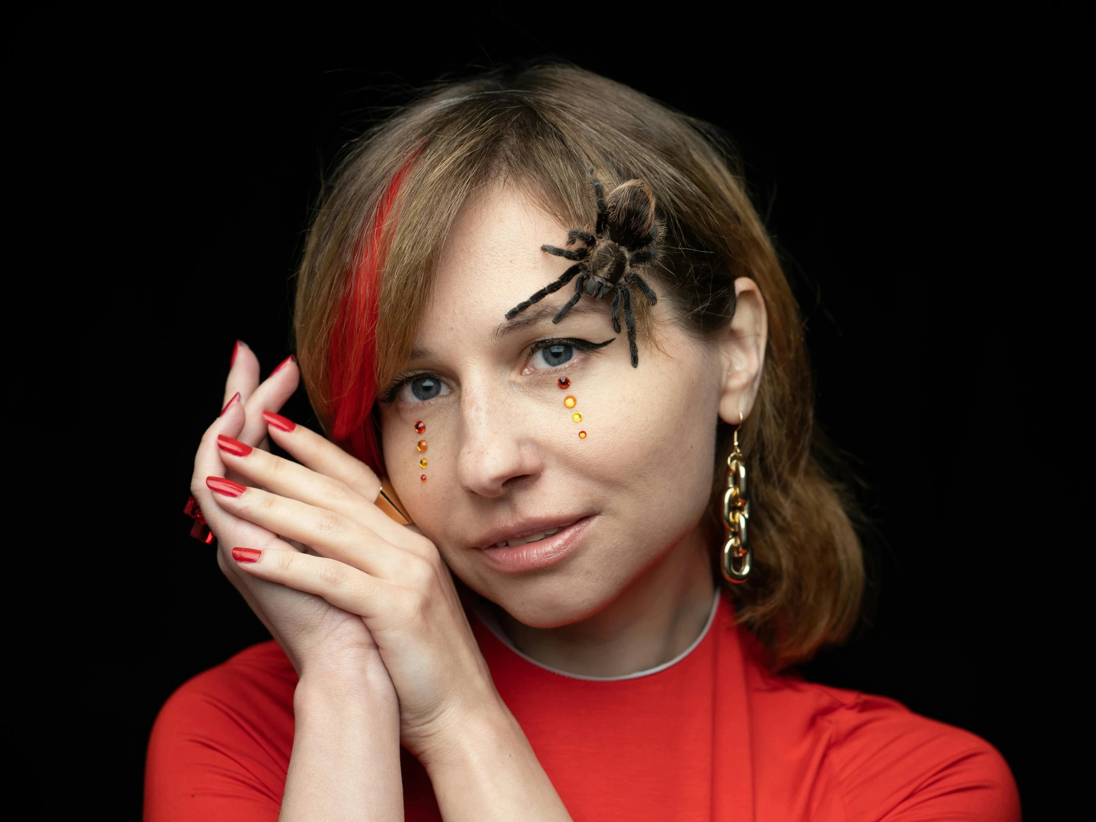 a woman with a spider painted on her face, an album cover, by Julia Pishtar, trending on pexels, antipodeans, red jewelry, hand on cheek, anna kovalevskaya, zoe kazan