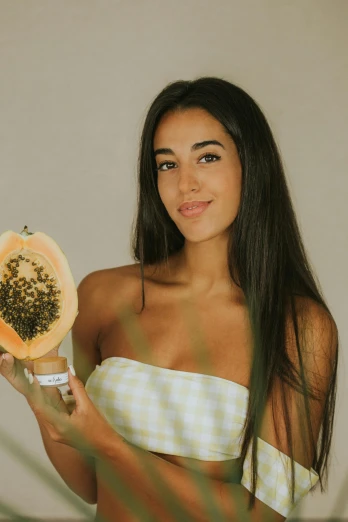 a beautiful young woman holding a slice of papana, by Olivia Peguero, instagram, hurufiyya, tanned skin, wearing a melon, promo image, seeds