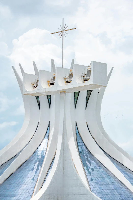 a very tall building with a cross on top of it, an abstract sculpture, inspired by Zaha Hadid, trending on unsplash, brazil, palace of the chalice, rounded roof, photo 1960