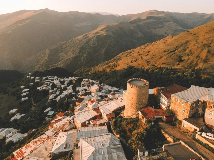 an aerial view of a small town in the mountains, an album cover, pexels contest winner, city of armenia quindio, old ruins tower, warm sunlight shining in, aykut aydogdu