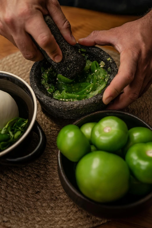 a close up of a person preparing food on a table, inspired by Ceferí Olivé, mortar and pestle, lime green, bao pnan, thumbnail