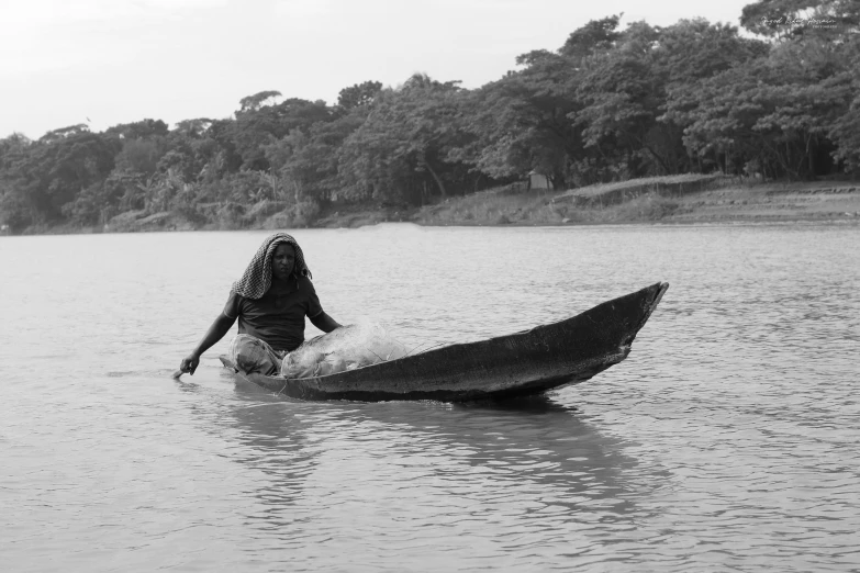 a black and white photo of a person in a boat, by Sunil Das, hurufiyya, ayahuasca shaman, people at work, african woman, photographic print