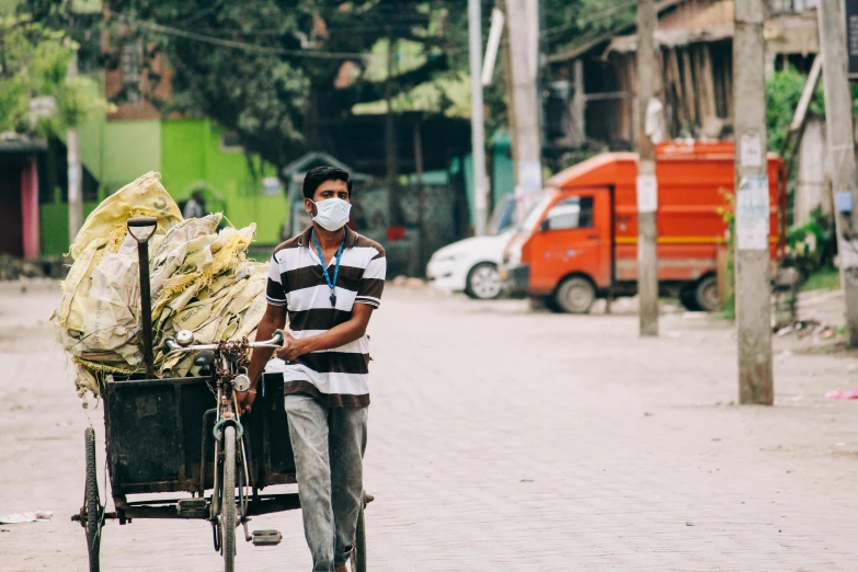 a man walking down a street with a cart full of bags, pexels contest winner, hurufiyya, surgical mask covering mouth, bangladesh, profile image, thumbnail