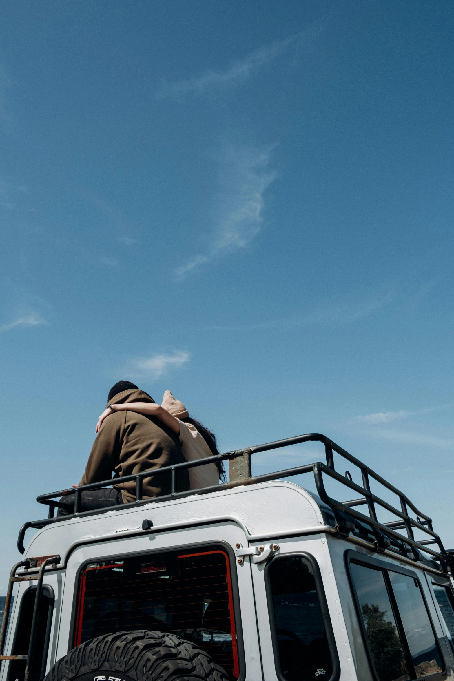 a man is sitting on top of a vehicle, a picture, by Jan Tengnagel, trending on unsplash, land rover defender, clear blue sky, comforting, 15081959 21121991 01012000 4k