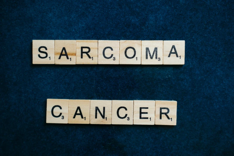 two scrabbles spelling sarcoma cancer on a blue background, on a dark background, sahara, trending on vsco, sakura