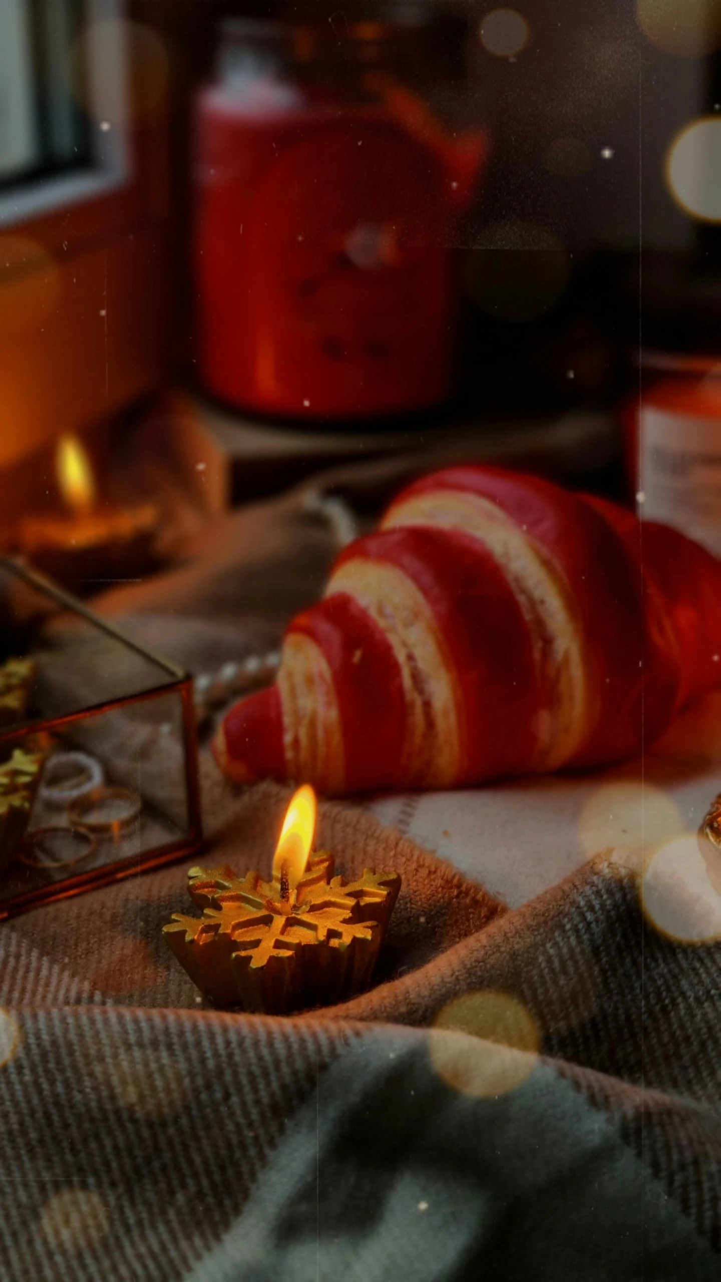 a candle that is sitting on a table, a still life, inspired by Ernest William Christmas, pexels, pastries, background image, cyber copper spiral decorations, red glow