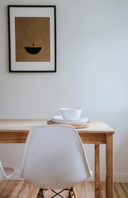 a white chair sitting next to a wooden table, poster art, unsplash, serene smile, kitchen table, zoomed in, tea