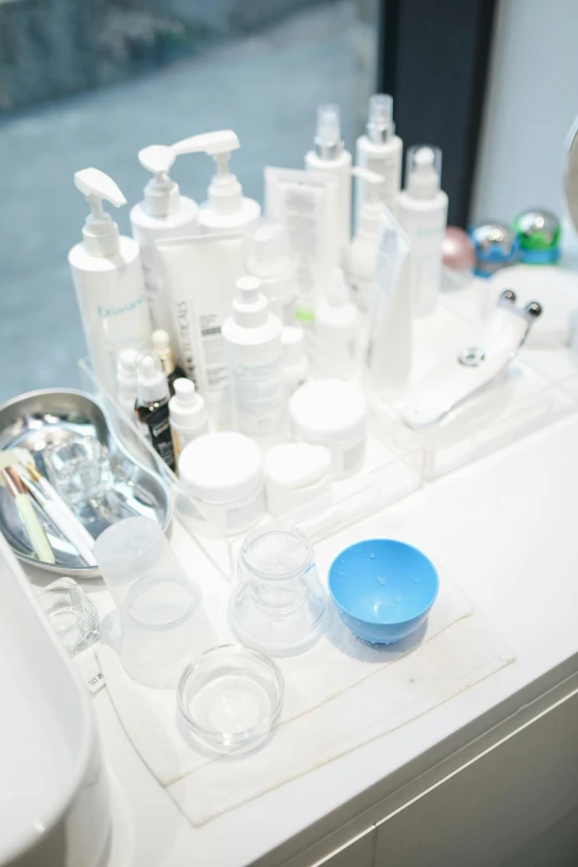 a white counter topped with lots of bottles and containers, by Miyamoto, facial precision, acne, detail shot, healthcare