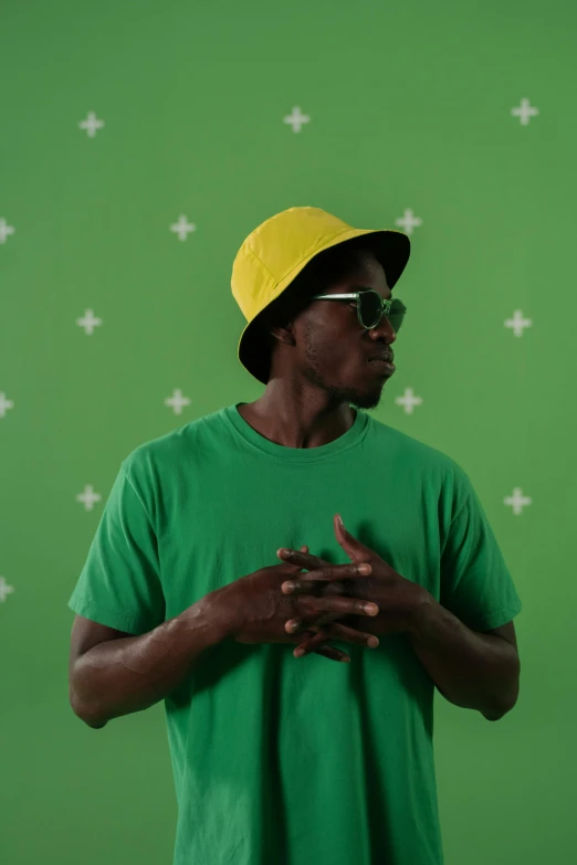 a man in a green shirt and a yellow hat, trending on unsplash, video art, ( ( dark skin ) ), green screen background, 15081959 21121991 01012000 4k, with a cool pose