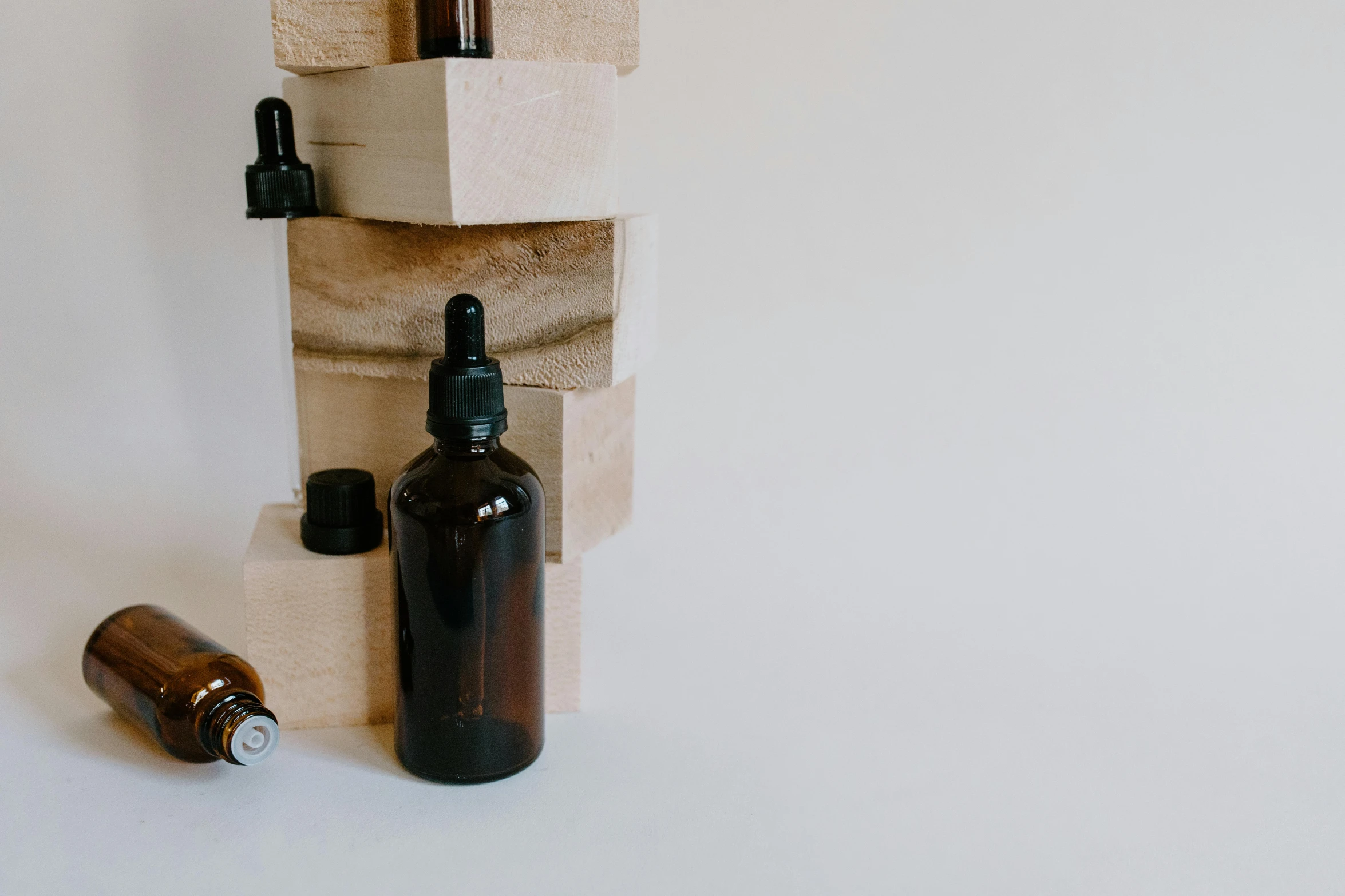 a couple of bottles sitting on top of a wooden block, trending on pexels, modernism, skincare, background image, profile pic, apothecary